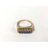 AN UNUSUAL YELLOW METAL LADIES RING SET WITH TWO ROWS OF FIVE STONES, ONE ROW CLEAR, THE OTHER BLUE,