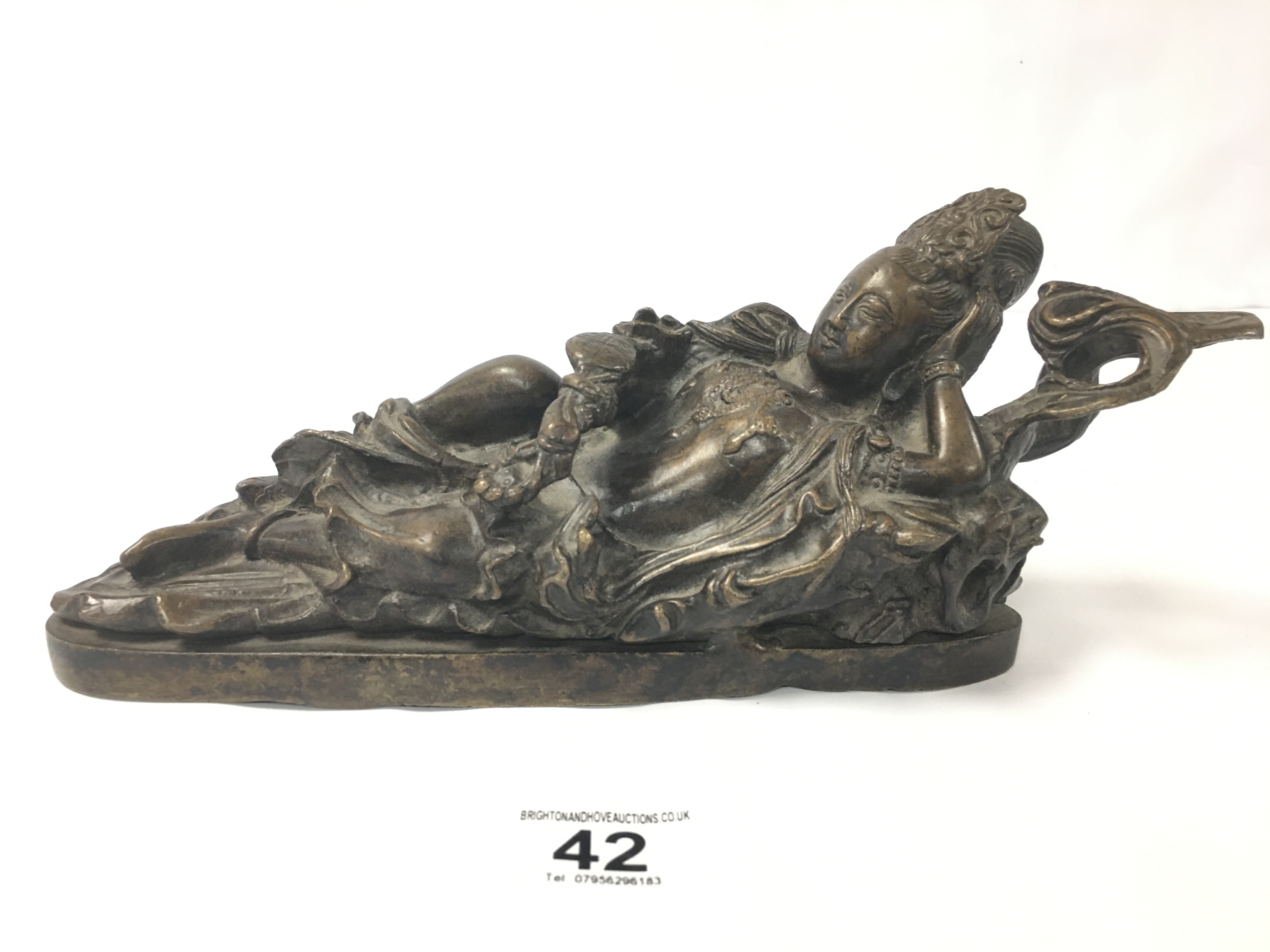 A ORIENTAL BRONZE FIGURE OF A RECLINING FEMALE DEITY, 30CM WIDE