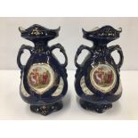 A PAIR OF BLUE GLAZED TWIN HANDLED CERAMIC VASES WITH CLASSICAL SCENE TO THE FRONT, 19CM HIGH,