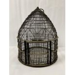 A METAL BEEHIVE SHAPED BIRD CAGE.