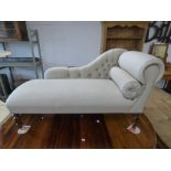 A MODERN CHAISE LOUNGE RAISED UPON FOUR TURNED SUPPORTS WITH CASTORS AND NEW UPHOLSTERY AND FIRE