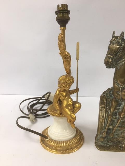 A GILT METAL AND MARBLE TABLE LAMP DEPICTING A CHERUB SAT UPON A PEDESTAL, STAMPED TO BASE "SPAIN"
