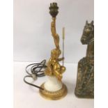 A GILT METAL AND MARBLE TABLE LAMP DEPICTING A CHERUB SAT UPON A PEDESTAL, STAMPED TO BASE "SPAIN"