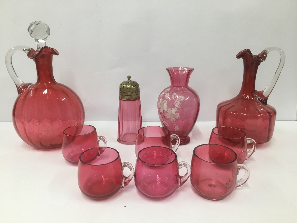 A GROUP OF CRANBERRY GLASS ITEMS, INCLUDING TWO DECANTERS, SUGAR SIFTER AND MORE, LARGEST 27CM HIGH