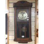 AN OAK WALL MOUNTED CLOCK WITH A WESTMINSTER CHIME