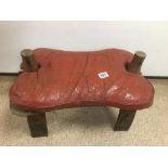 A VINTAGE LEATHER AND WOOD CAMEL STOOL.