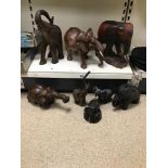 A COLLECTION OF CARVED WOODEN FIGURES OF ELEPHANTS, INCLUDING A NOVELTY CANDLESTICK AND MORE,