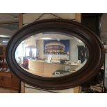 A VICTORIAN WOODEN MIRROR OVAL BEVELLED EDGED