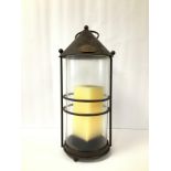 A LARGE METAL AND GLASS HANGING LANTERN WITH LARGE CANDLE, 51CM HIGH