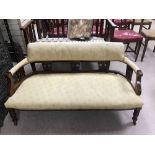 A VICTORIAN MAHOGANY TWO SEATER SEAT ON ORIGINAL CASTOR IN YELLOW FABRIC.