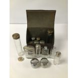 A COLLECTION OF ASSORTED GLASS TOILETRIES BOTTLES WHITE METAL AND BRASS LIDS, SOME IN AN EARLY METAL