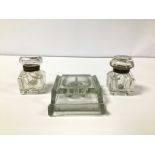 A THREE PIECE GLASS DESK SET, COMPRISING TWO LIDDED INKWELLS AND A PEN REST