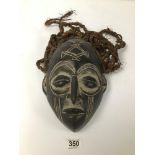 AN EARLY 20TH CENTURY EBONISED DAN KWELE MASK WITH CARVED DETAIL AND SCARIFICATION MARKS AND ADORNED