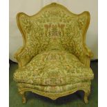 A French style upholstered armchair on four scroll legs