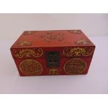 An oriental lacquered leather box, the hinged cover and sides decorated with geometric forms