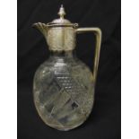 A Victorian oval cut glass claret jug with silver leaf engraved mount, hinged cover and angled