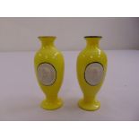 A pair of continental yellow ground porcelain vases with cameos to the sides