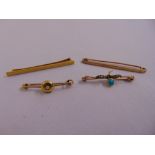 A quantity of gold jewellery to include three brooches and a tie clip