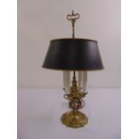 A four branch brass desk lamp on shaped circular base with original shade