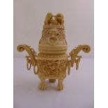 An oriental composition incense burner profusely carved throughout on three paw supports
