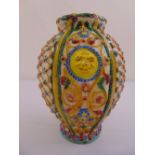 A Majolica Italian baluster vase decorated with stylised masks and geometric forms