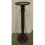 A mahogany torchere on carved pedestal and circular base and top