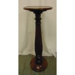 A 19th century mahogany torchere, the circular top supported by a fluted baluster column on raised