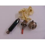 A Victorian silver childs rattle with coral mouth piece, a silver orb pin cushion and green glass