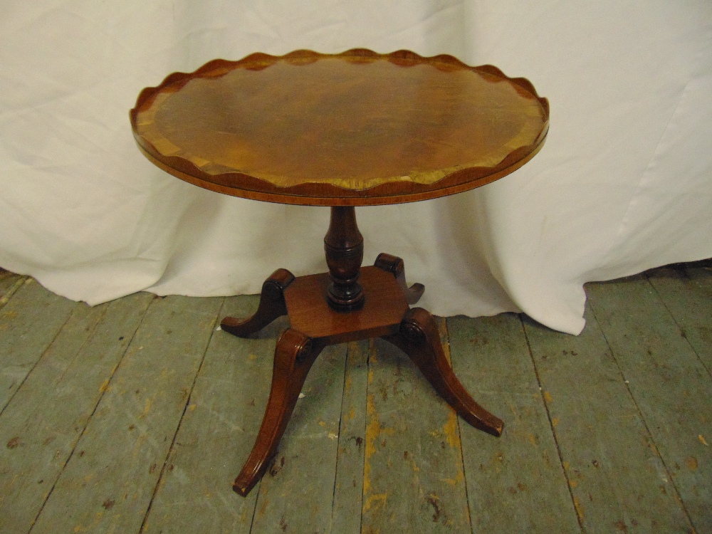 A mahogany oval side table with pie crust border on four outswept legs