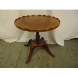 A mahogany oval side table with pie crust border on four outswept legs