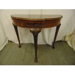 A mahogany demilune card table, the hinged top with carved border on tapering cylindrical legs