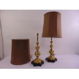 A pair of turned brass lamp stands with silk shades