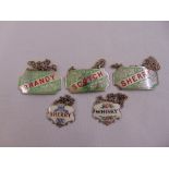 A pair of silver and enamel wine labels and three silver plated and enamel wine labels all with