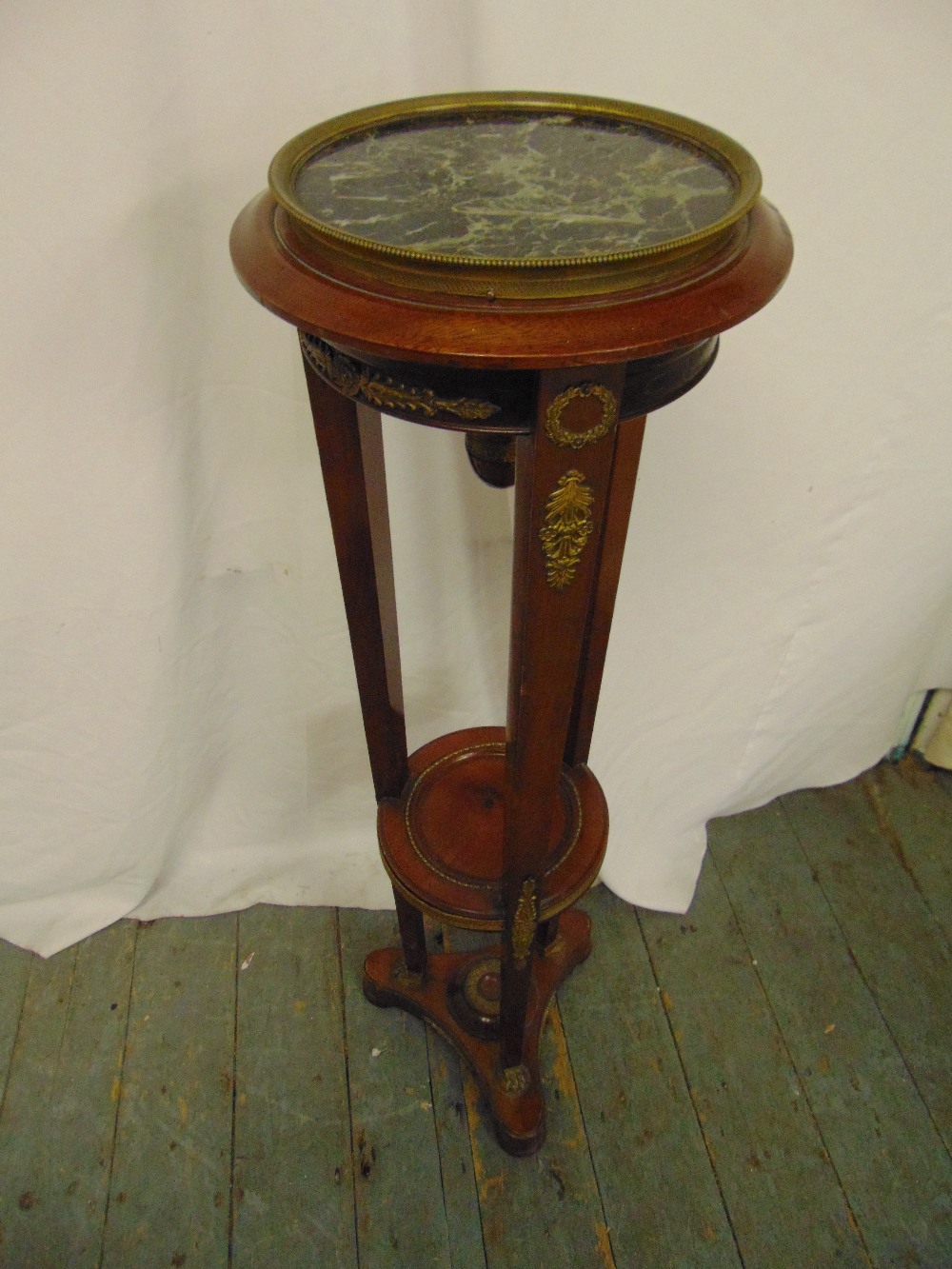 A continental mahogany torchere, the circular top on three tapering rectangular supports with