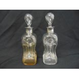 A pair of glass glug glug decanters with silver collars and drop stoppers