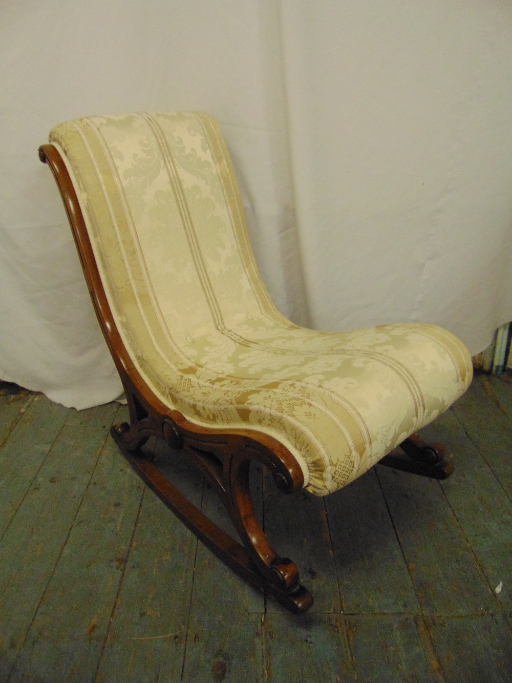 A Victorian mahogany upholstered rocking chair