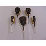 Four silver and tortoiseshell hair brushes and a matching hand mirror