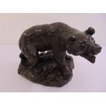 A bronzed figurine of a bear on naturalistic base, indistinctly signed to the base