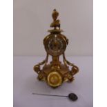 A brass mantle clock, the circular movement and dial on cylindrical column and raised circular base,