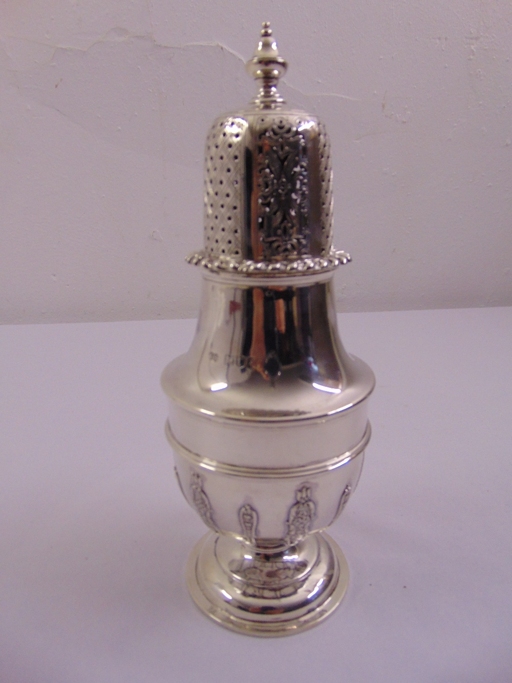 A Victorian silver sugar caster vase form with applied strapwork, pierced pull off cover on raised