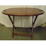 An oval mahogany butlers tray with brass hinges on folding stand