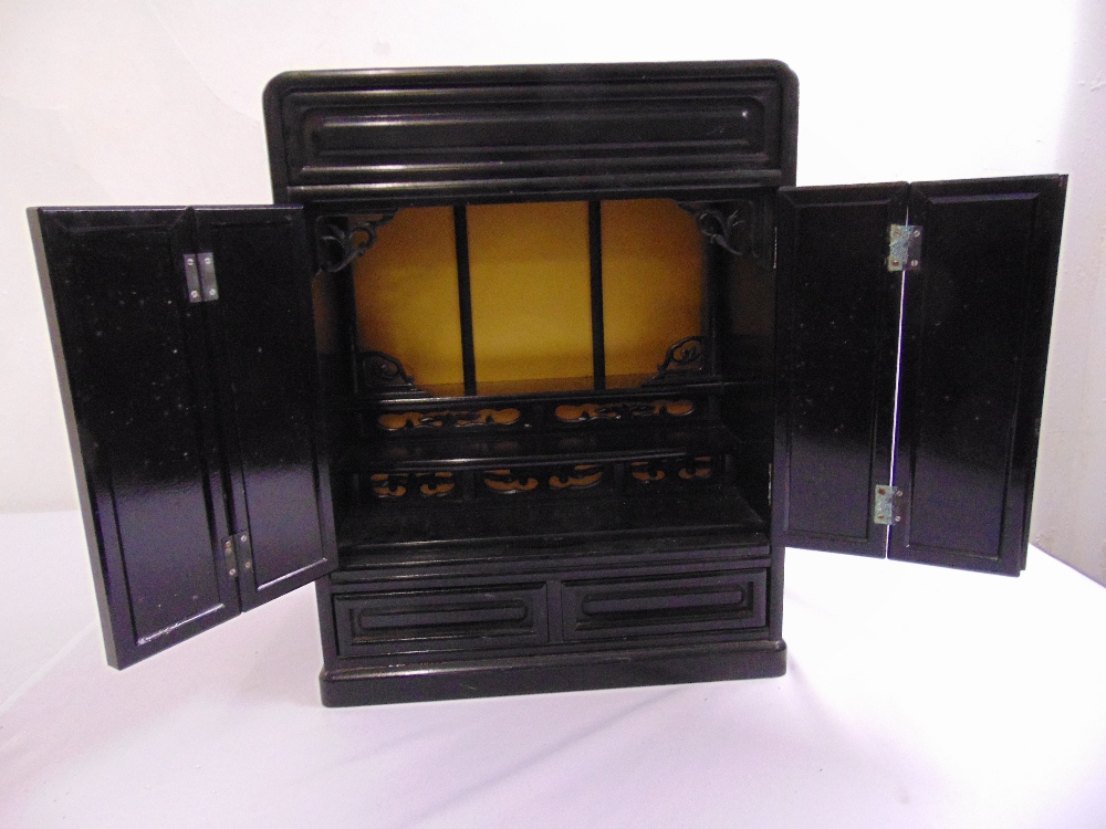 An oriental rectangular ebonised wooden cabinet, the hinged doors revealing fitted interior