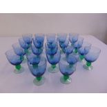 Twenty two coloured drinking glasses on raised circular bases