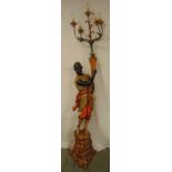 A late 19th early 20th century polychromatic carved wooden Blackamoor supporting a five branch