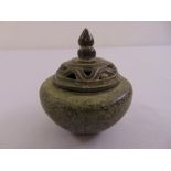 A Chinese bronze incense burner of conical form with scroll carved pull off cover