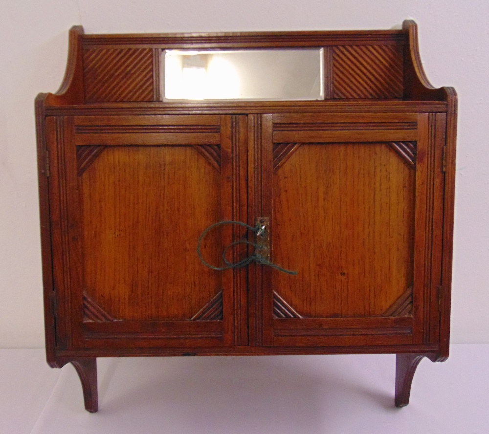 An Edwardian rectangular mahogany wall mounted cabinet with two moulded hinged doors