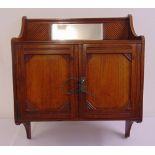 An Edwardian rectangular mahogany wall mounted cabinet with two moulded hinged doors