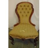 A Victorian spoon back upholstered salon chair with carved hardwood frame and button back, on