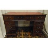 A mahogany rectangular pedestal desk with inlaid red leather top and brass swing handles on four