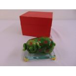 A Chinese greenstone figurine of a pig on rectangular perspex base with gilt metal feet, in original